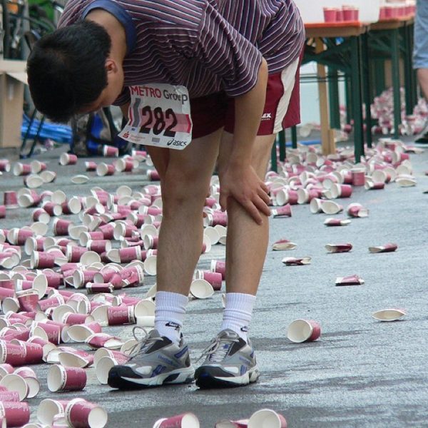 Marathon runner taking pause among water cups