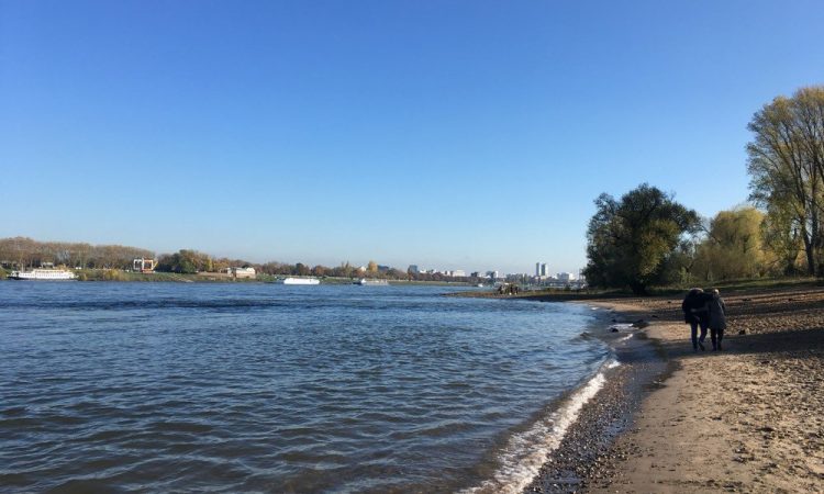 River, beach and couple walking